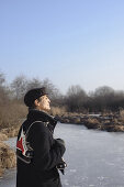 Senior man with ice skates at lake Ammersee, Upper Bavaria, Germany