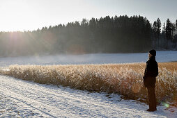 Senior man watching winter scenery, Windach, Upper Bavaria, Germany
