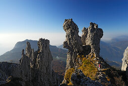 Woman hiking between pinnacles of Grigne, Bergamo Alps, Como, Lombardy, Italy