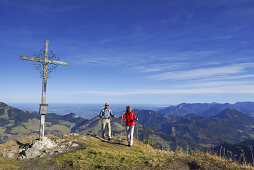 Paar erreicht Gipfelkreuz, Kleiner Traithen, Bayerische Voralpen, Bayern, Deutschland