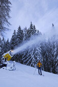 Woman skiing near snow cannon, Wiedersberger Horn, Kitzbuehel Alps, Tyrol, Austria