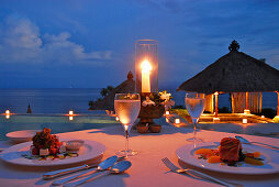 Gedeckter Tisch am Pool im Amankila Resort am Abend, Candi Dasa, Ost Bali, Indonesien, Asien