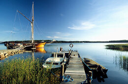 Blick auf ein Boot an einem Steg in den Schären, Finnland, Europa