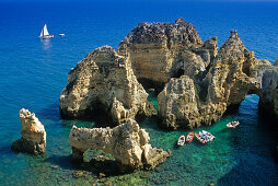 Boats off the rocky coast in the sunlight, Ponta da Piedade, Algarve, Portugal, Europe