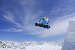 Snowboarder jumping from a kicker, ski area Soelden, Oetztal, Tyrol, Austria