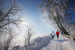 Couple jogging in winter, Muensing, Bavaria, Germany