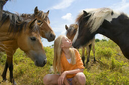 Small girl in a pony herd.