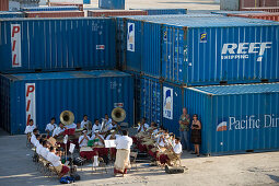 Die Tongan Brass Band spielt zwischen Containern am Hafen, Nuku'alofa, Tongatapu, Tonga, Südsee, Ozeanien