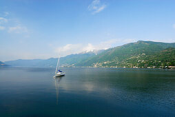 Segelboot ankert im Lago Maggiore mit Gridone und Pizzo Leone im Hintergrund, Ascona, Lago Maggiore, Tessin, Schweiz