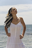 Woman in white dress breathing by the sea