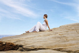 Woman relaxing in a cliff by the sea