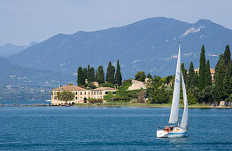 Segelboot steuert Punta San Vigilio bei Garda an. Das Haus an der Lanspitze ist das älteste Hotel am Gardasee, Provinz Verona, Veneto, Italien