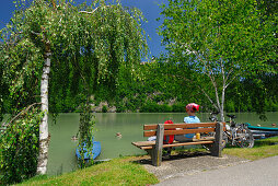 Woman sitting on bench near river Danube, Danube Cycle Route Passau to Vienna, Upper Austria, Austria