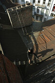 Chimney sweep on corrugated iron roof, Berlin, Germany