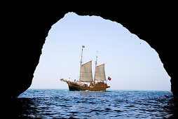 Blick aus Hoehle auf Segelschiff Santa Bernada, fuer touristische Zwecke umgebautes altes Segelschiff, Fahrten entlang der Felsenkueste, Portimao, Algarve, Portugal