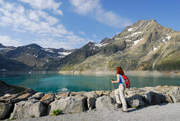Female hiker looking over reservoir Finstertal, Sellrain, Stubai Alps, Tyrol, Austria