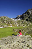 Frau rastet am Stubensee, Stubaier Alpen, Trentino-Südtirol, Italien