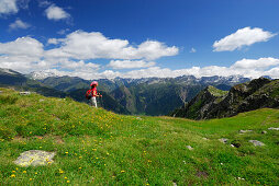 Woman hiking over mountain pasture, Valle Santa Maria, Ticino Alps, Canton of Ticino, Switzerland