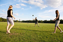 Young people playing volleyball on a meadow, Leipzig, Saxony, Germany