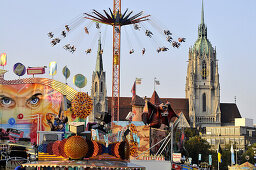 Menschen auf dem Kettenkarussell, Oktoberfest mit Paulskirche, München, Bayern, Deutschland, Europa