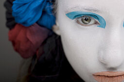 Frau mit weißer Gesichtsschminke, blauen Augen und roten Lippen