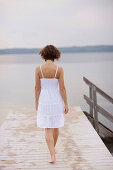 Mid adult woman walking along jetty, Starnberger See, Upper Bavaria, Germany