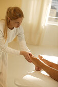 Young woman performing an ayurveda foot massage, Wellness