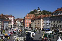 Hauptplatz mit den Ruinen der zerstörten Burg des Schlossbergs und dem Uhrturm, dem Symbol der Stadt Graz, Steiermark, Österreich