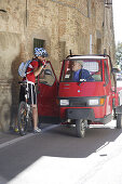 Mountainbikerin vor einem Transporter in Panicale, Umbrien, Italien, Europa