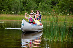 Ein Mädchen und eine Frau in einem Kanu auf der Insel Norrbyskär, Västerbotten, Schweden, Europa