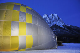 Hot-air balloon lying on the ground and being filled, Waxensteine in background, Garmisch-Partenkirchen, Wetterstein range, Bavarian alps, Upper Bavaria, Bavaria, Germany, Europe