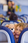 Junge mit Teddybär in einem Flugzeug, Flughafen München, Bayern, Deutschland