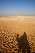 Shadow of a tourist on a camel and the pyramids of Giza, Cairo, Egypt, Africa