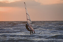 Windsurfer surfing the waves in the evening light, St Peter-Ording, Schleswig-Holstein, North Sea coast, Germany