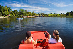 Two women in a pedal boat on lake Staffelsee, Seehausen, Upper Bavaria, Bavaria, Germany