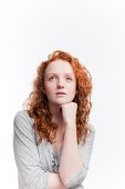 Single red haired young woman in studio on white background