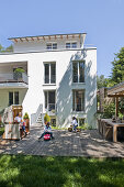 Mutter und zwei Kinder auf der Terrasse von einem Einfamilienhaus, Hamburg, Deutschland