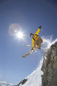 Skifahrer springt über Fels, Disentis, Oberalppass, Kanton Graubünden, Schweiz