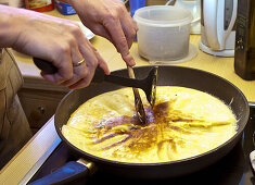 Cook cutting-up the sugared raisin pancake, Molterau alpine hut, Region of Hochkönig, Salzburger Land, Austria