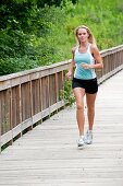 30 Jahre alte blonde Frau joggt in Trainingskleidung