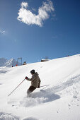 Man skiing in deep snow, Schlosslelift, Hirschegg, Kleinwalsertal, Vorarlberg, Austria