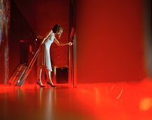 Woman with suitcase on hotel floor, Madrid, Spain