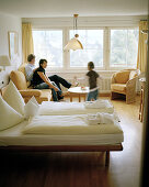 Mother, father and daughter relaxing in the hotel room, organic Hotel Chesa Valisa, Hirschegg, Kleinwalsertal, Styria, Austria