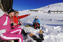 Menschen machen eine Pause nach dem Schneeschuhlaufen, Eggenalm, Reit im Winkl, Chiemgau, Bayern, Deutschland, Europa