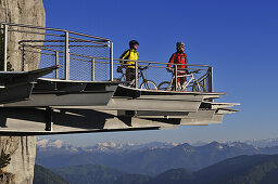 People on mountain bikes on viewing platform at Triassic Park, Reit im Winkl, Bavaria, Germany, Europe