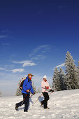 Menschen wandern auf Winterwanderweg in verschneiter Landschaft, Hemmersuppenalm, Reit im Winkl, Chiemgau, Bayern, Deutschland, Europa