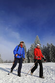 People hiking on winter hiking trail in snowy landscape, Hemmersuppenalm, Reit im Winkl, Chiemgau, Bavaria, Germany, Europe