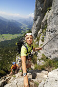 View at couple at rock face, Schuasta Gangl, Gamssteig fixed rope route, Steinplatte, Reit im Winkl, Chiemgau, Upper Bavaria, Bavaria, Germany, Europe