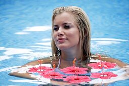 Adult, Adults, Bathe, Bathes, Bathing, Beauty, Blonde, Blondes, Caucasian, Caucasians, Color, Color image, Colour, Contemporary, Daytime, exterior, face, faces, Fair-haired, Female, Float, Floating, flower, flowers, headshot, headshots, Hibiscus, Horizont