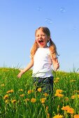 girl playing with bubbles in field of Dandelions, Zuercher Oberland, Zuerich, Switzerland